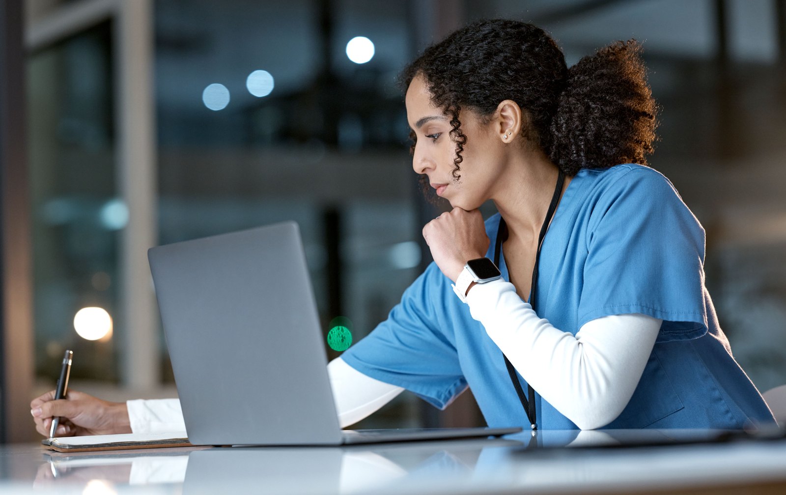 tilt-healthcare-challenge-cbx61520429 Provider writing notes at a laptop late in the evening