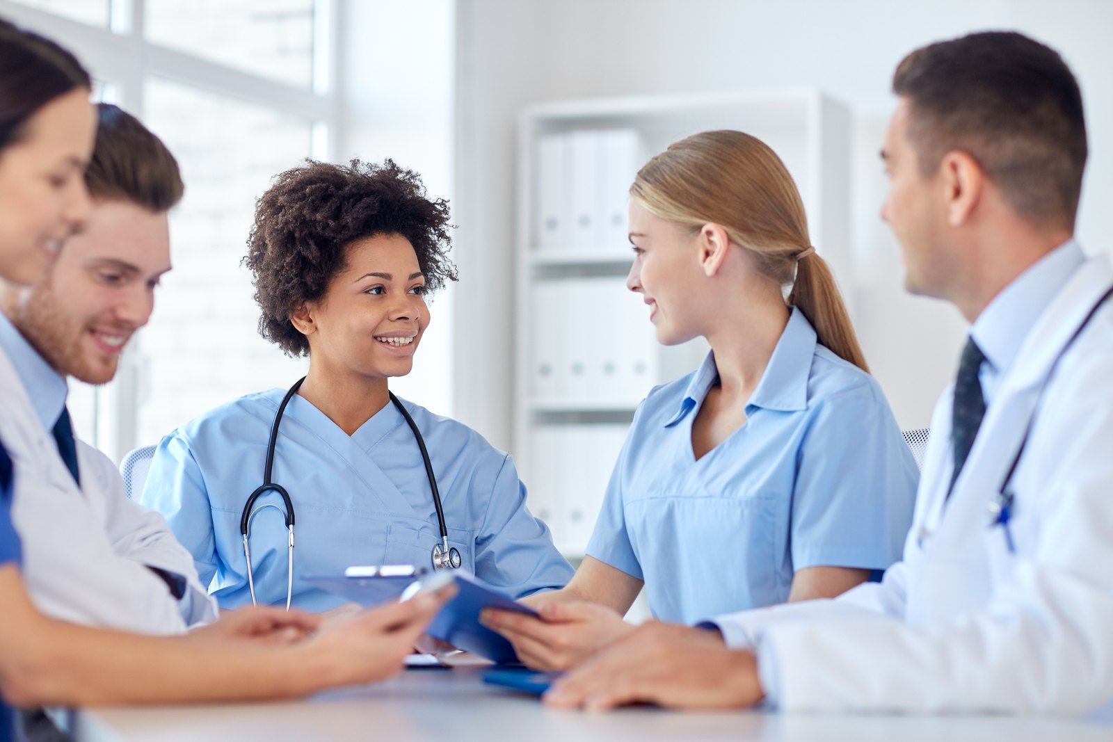 tilt-healthcare-hero-cbx13177305 Care team reviewing a tablet together at a meeting table
