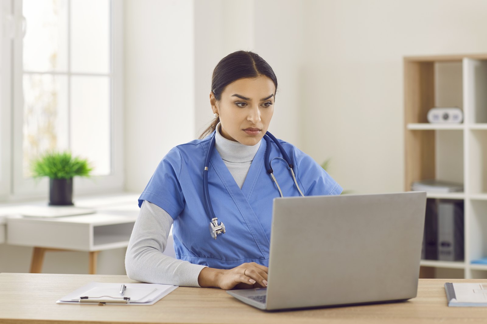tilt-horizon-hero-cbx60360449 Provider working at a laptop in a bright office