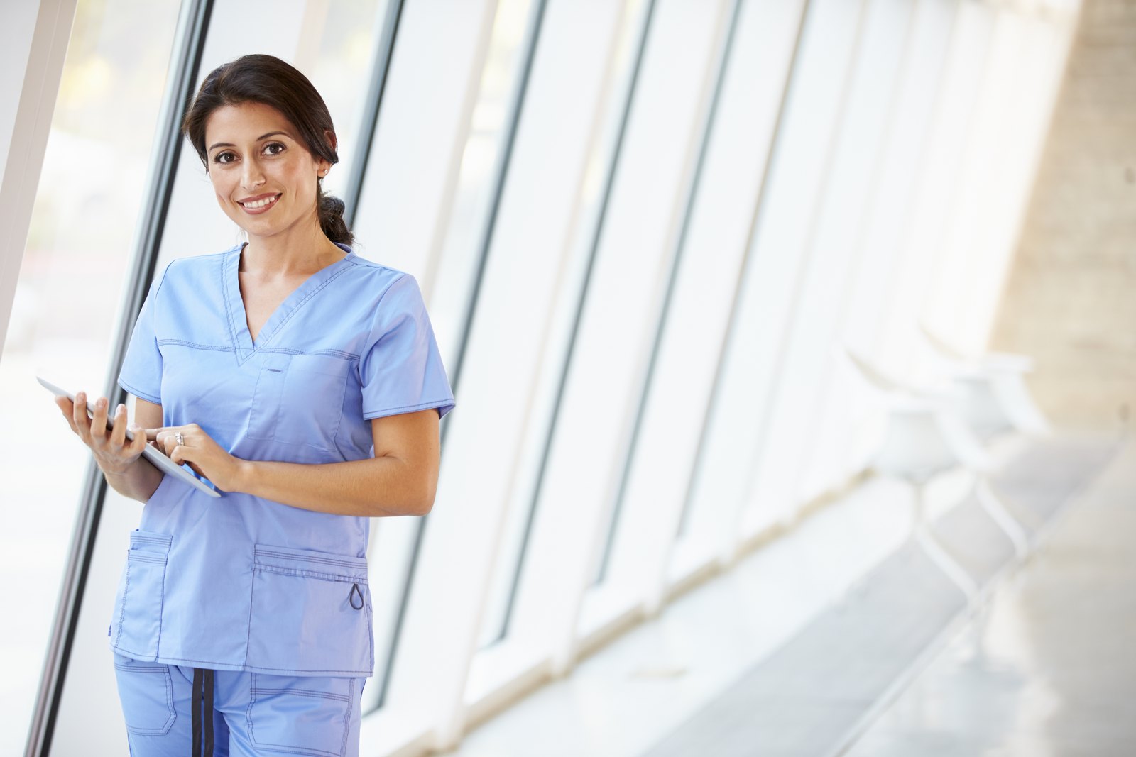 tilt-horizon-success-cbx6241577 Nurse using a tablet in a clinic corridor